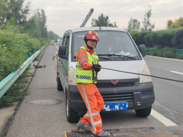 亳州中心阜陽段上行K376施救員徐建才調(diào)整拖車鋼絲繩，開展救援行動。.jpg